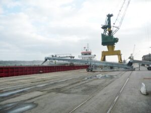 Bandes transporteuses équipées de capots de protection qui effectuent le chargement vrac d'un bateau