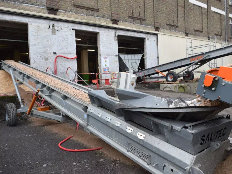 A conveyor on a building site. The conveyor is used to transfer soil inside a building.